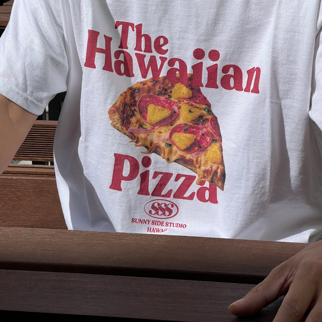 White t-shirt with 'The Hawaiian Pizza' graphic and text, worn by a person.